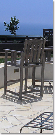 Chair on new stone patio with new walls, stucco and recessed lighting in walls