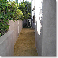 Concrete walls, stucco, and decomposed granite pathway